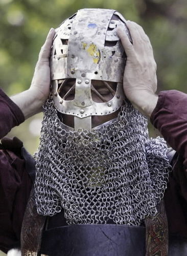 Dave Horvath adjusts the fit of his chain mail helmet as he gets dressed for the combat of the night at the NDSU chapter of the Society for Creative Anachronism.