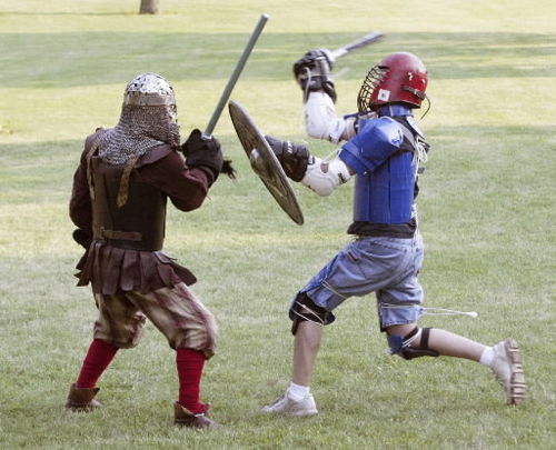 Matt Anderson, right, lunges toward Dave Horvath as they battle during the group practice night. Participants are encouraged to make their own medieval costumes as well as protective padding. 
